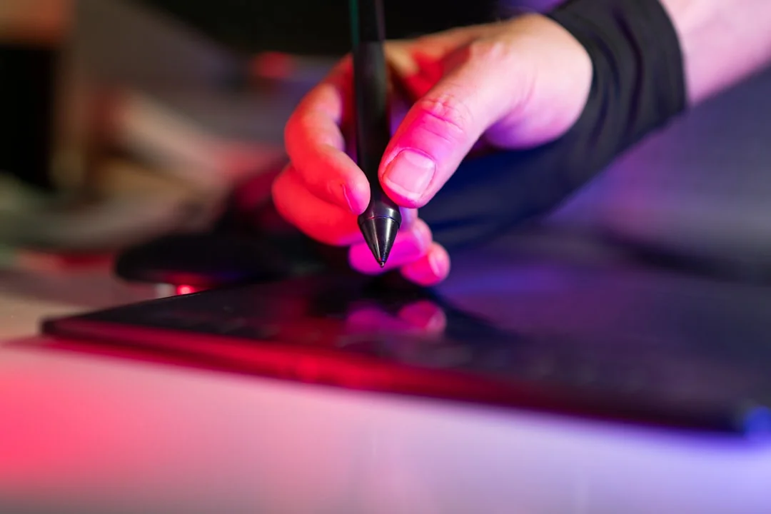 Close-up of hands typing on a laptop next to a cup of coffee on a wooden desk.